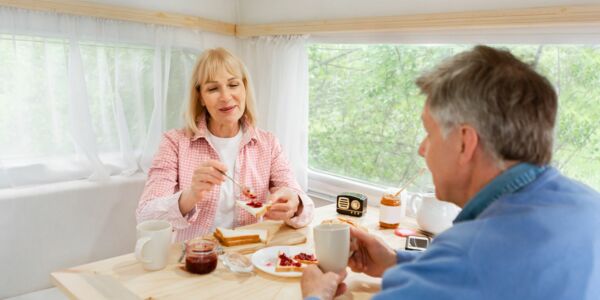 Älteres Ehepaar frühstückt im Camper